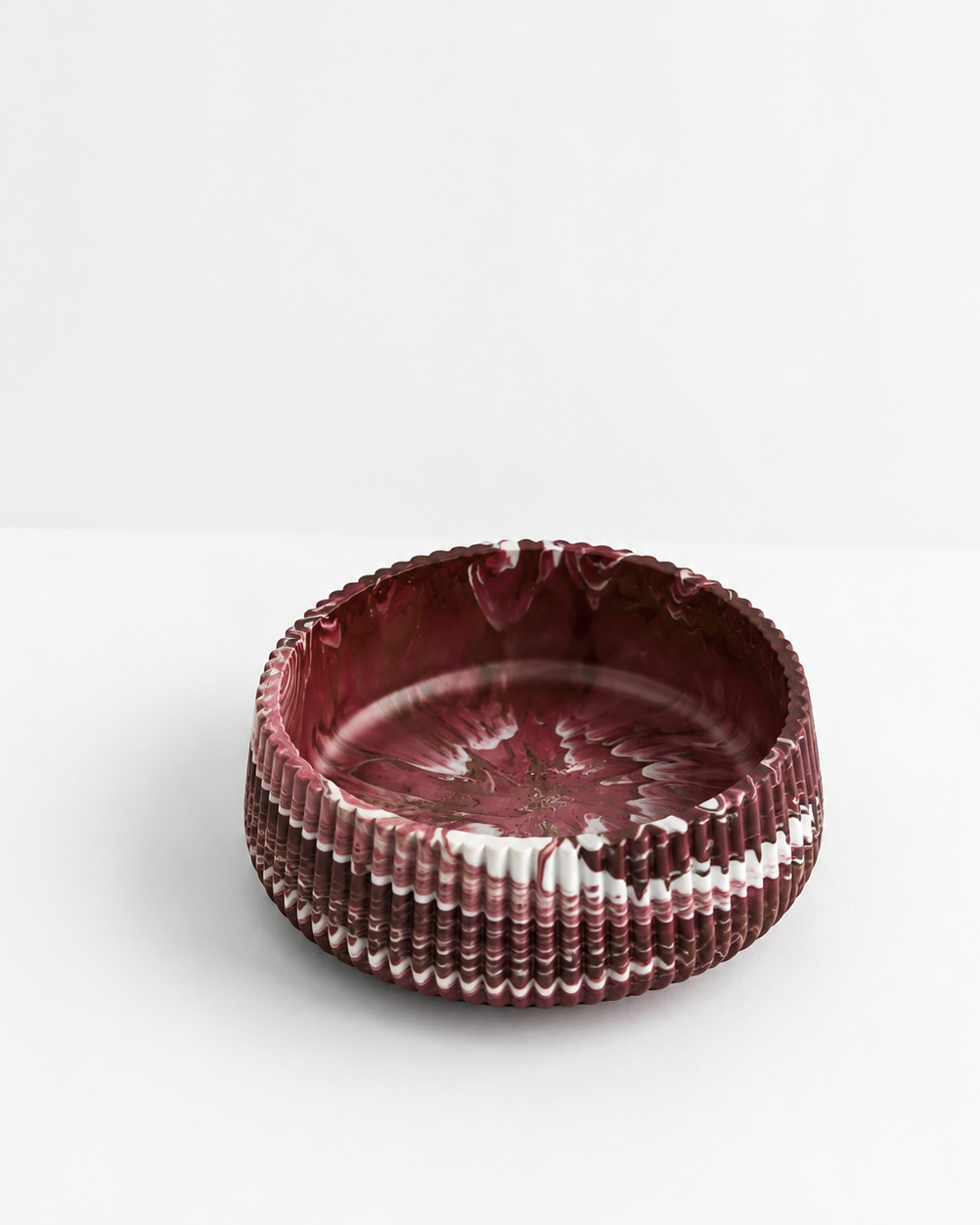 A large 20cm diameter round decorative bowl with a textured, ribbed exterior and a marbled interior in deep burgundy and white, set against a clean white background.