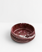 A large 20cm diameter round decorative bowl with a textured, ribbed exterior and a marbled interior in deep burgundy and white, set against a clean white background.